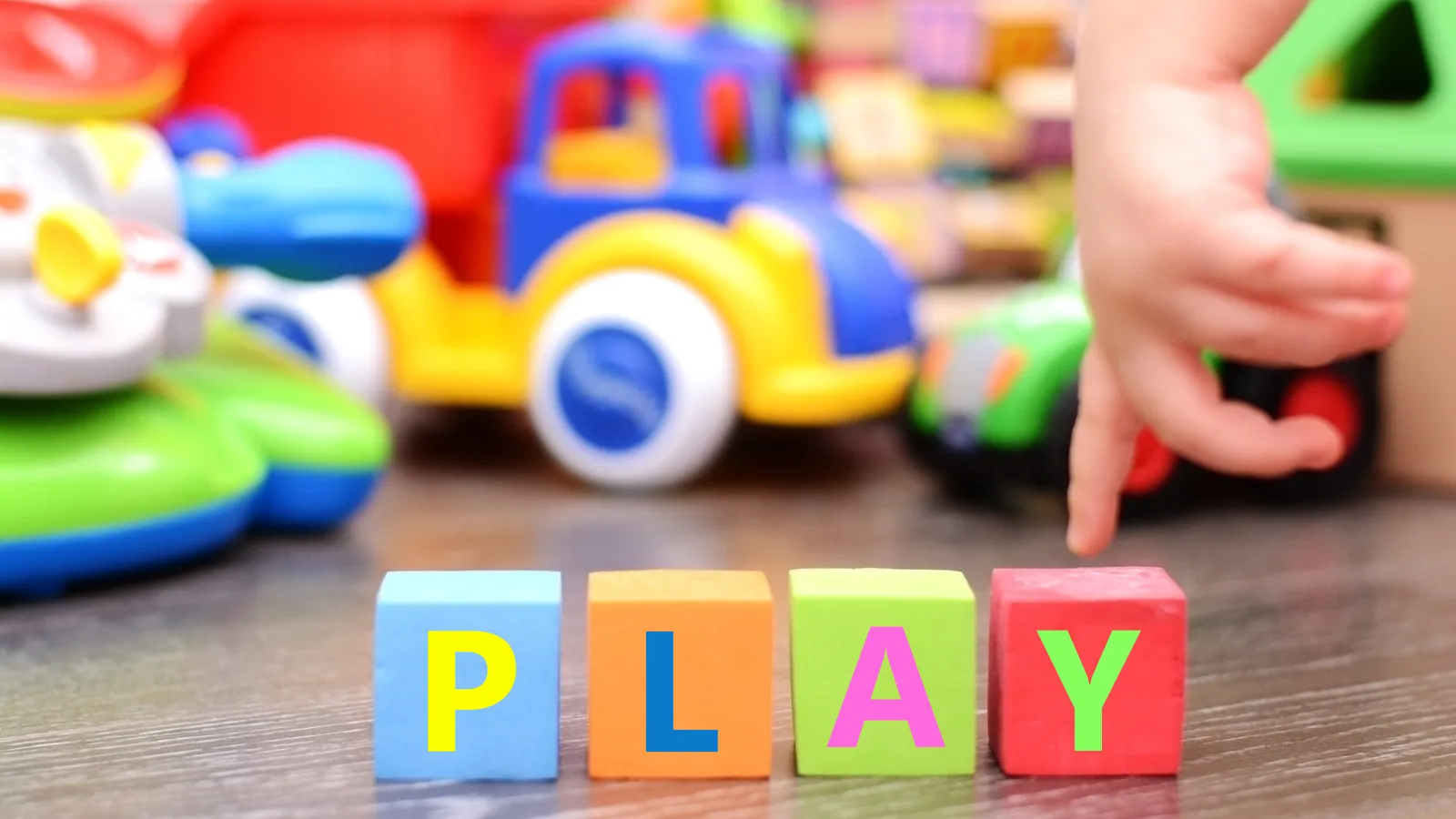 Baby's hands playing with colourful toy cubes and blocks