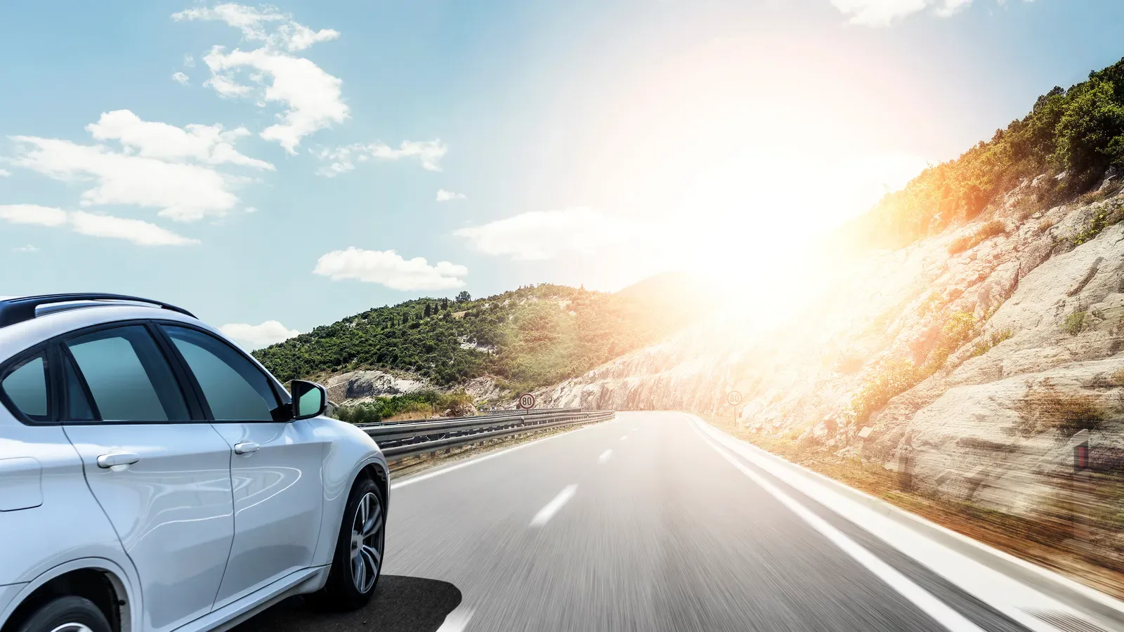 Car driving along an open road on a family road trip