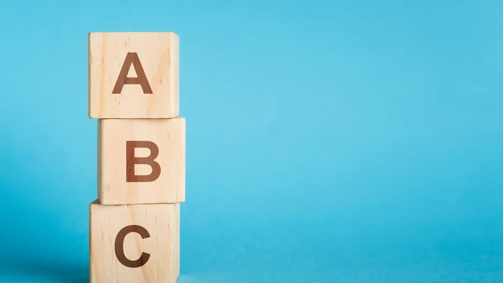 Wooden alphabet cubes stacked in a short column