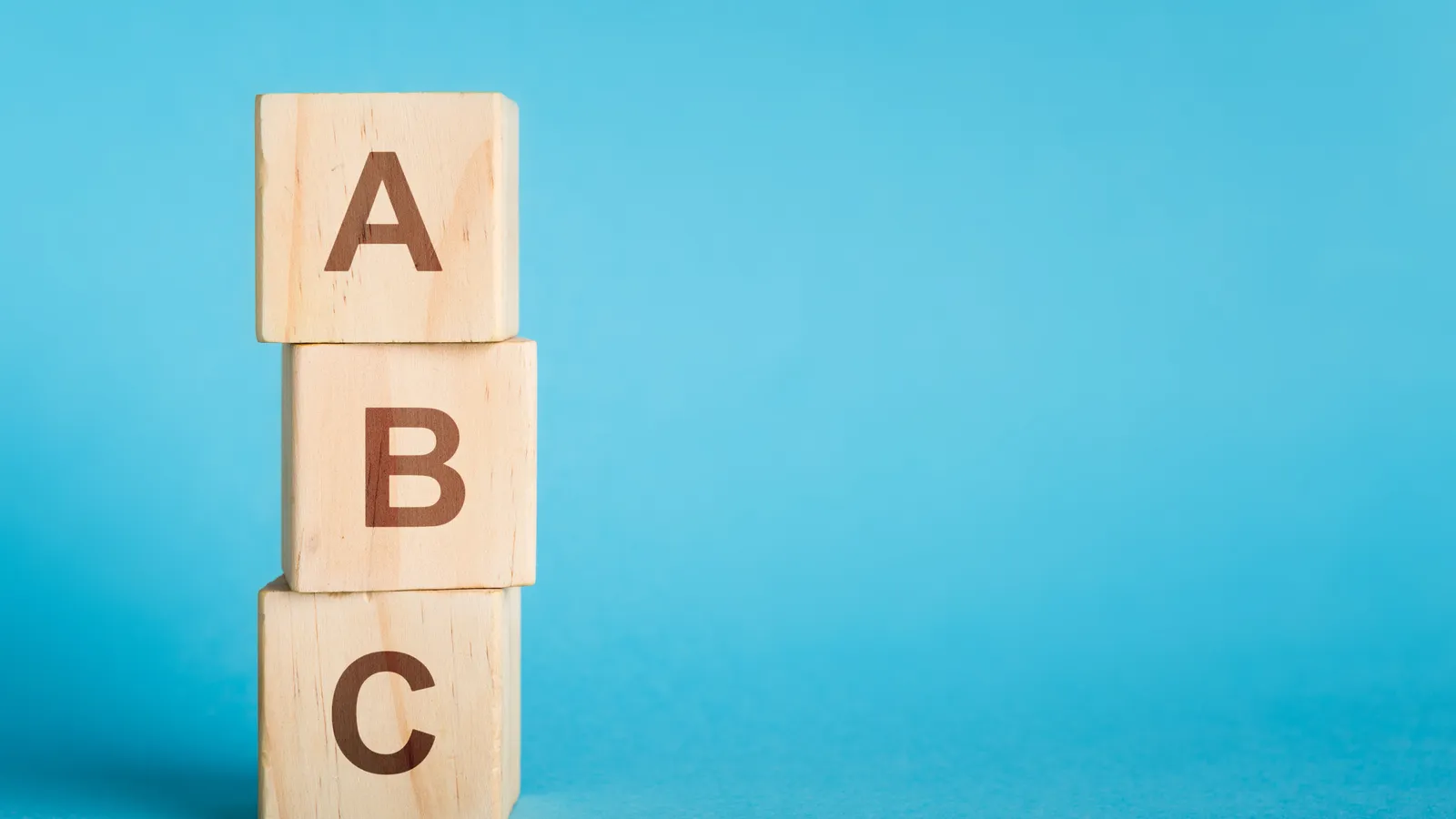 Wooden alphabet cubes stacked in a short column