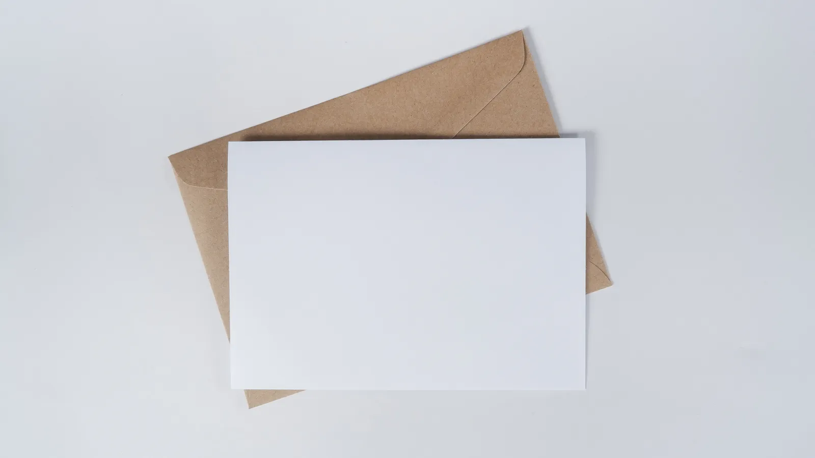 Blank cards and a kraft envelope arranged on a plain surface