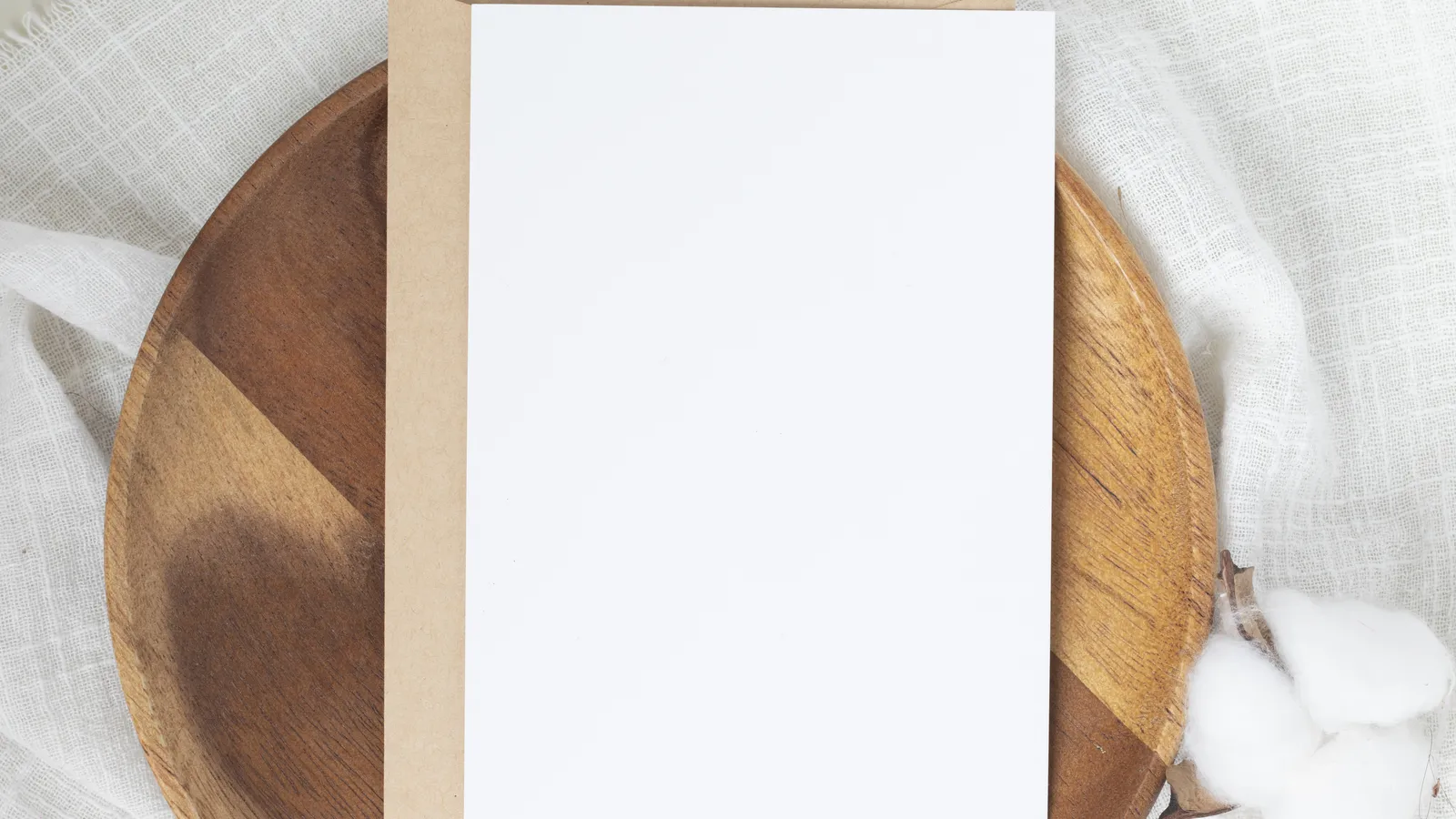 Blank greeting card with a pen and soft neutral baby items on a table