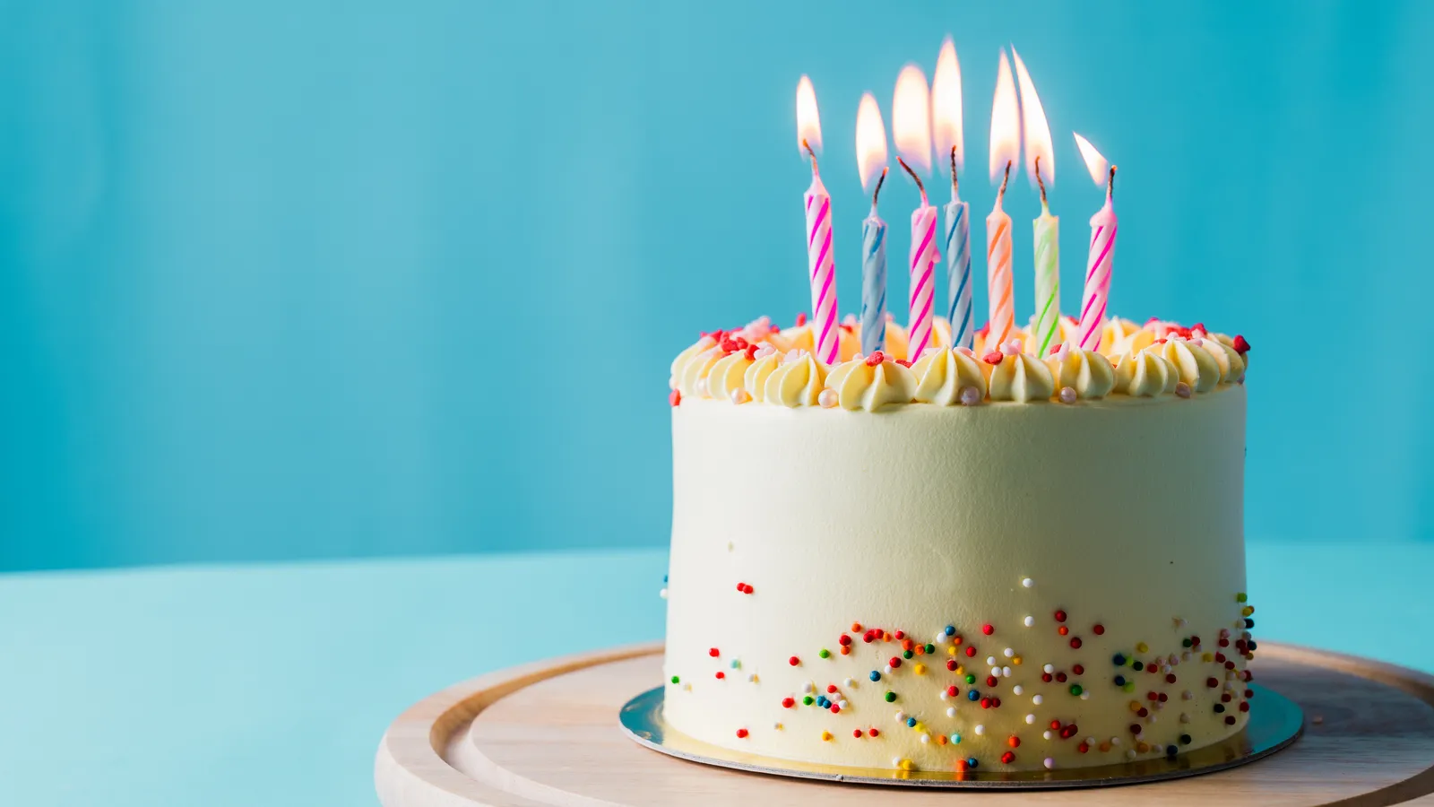 Birthday cake topped with lit candles ready for a first birthday
