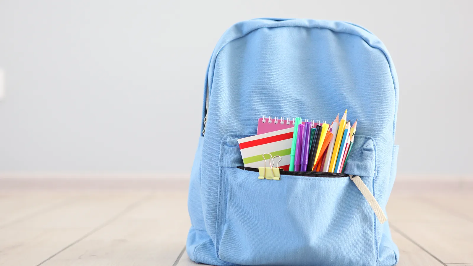 Child's school backpack and stationery ready for the first day of preschool