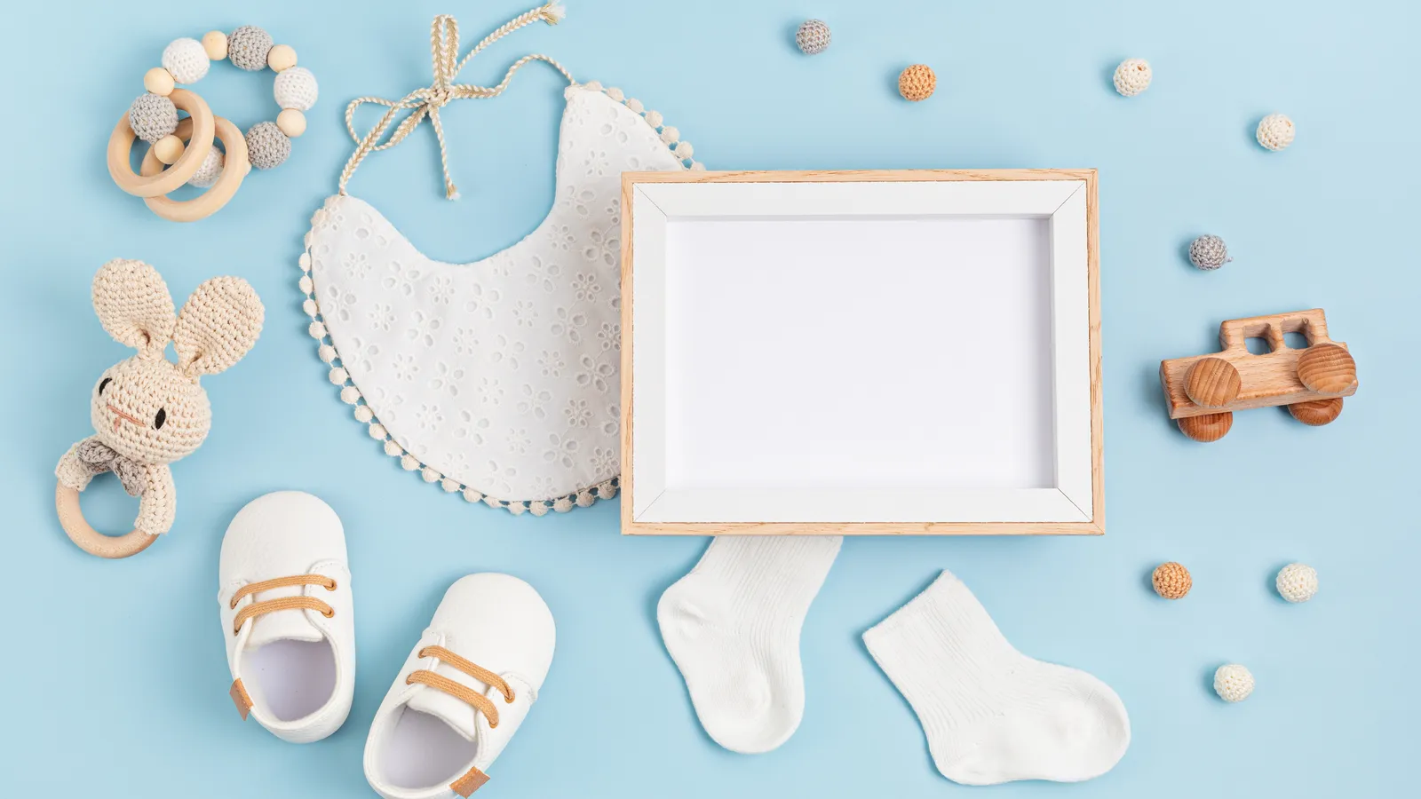 Flat lay of white baby essentials, blanket and accessories for a baby shower gift