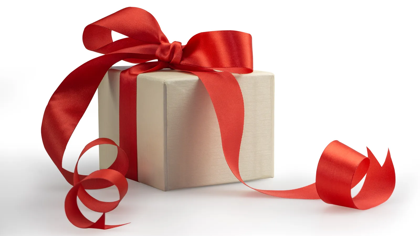Keepsake gift box with ribbon and a small memento on a soft neutral background