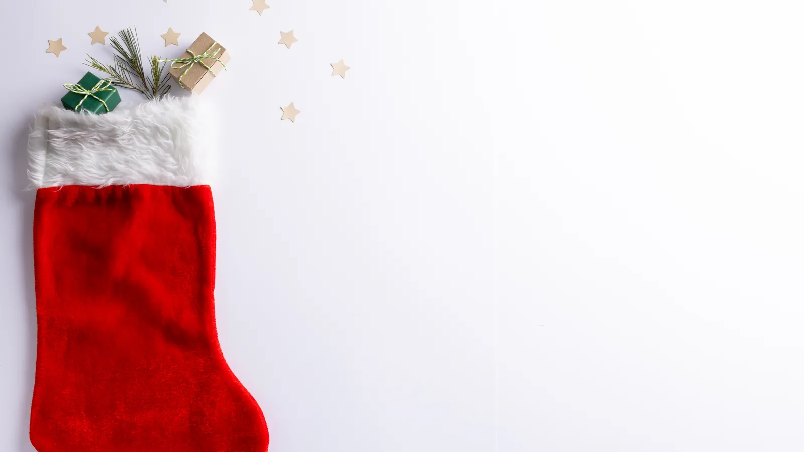 Small wrapped gifts and festive decorations laid out for Christmas stockings