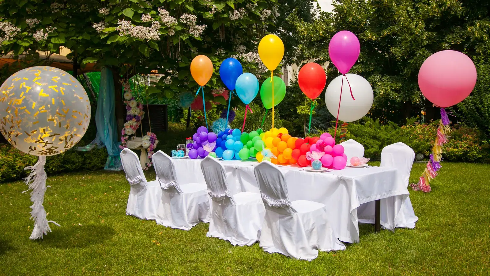 Birthday party table set with colourful balloons and simple decorations