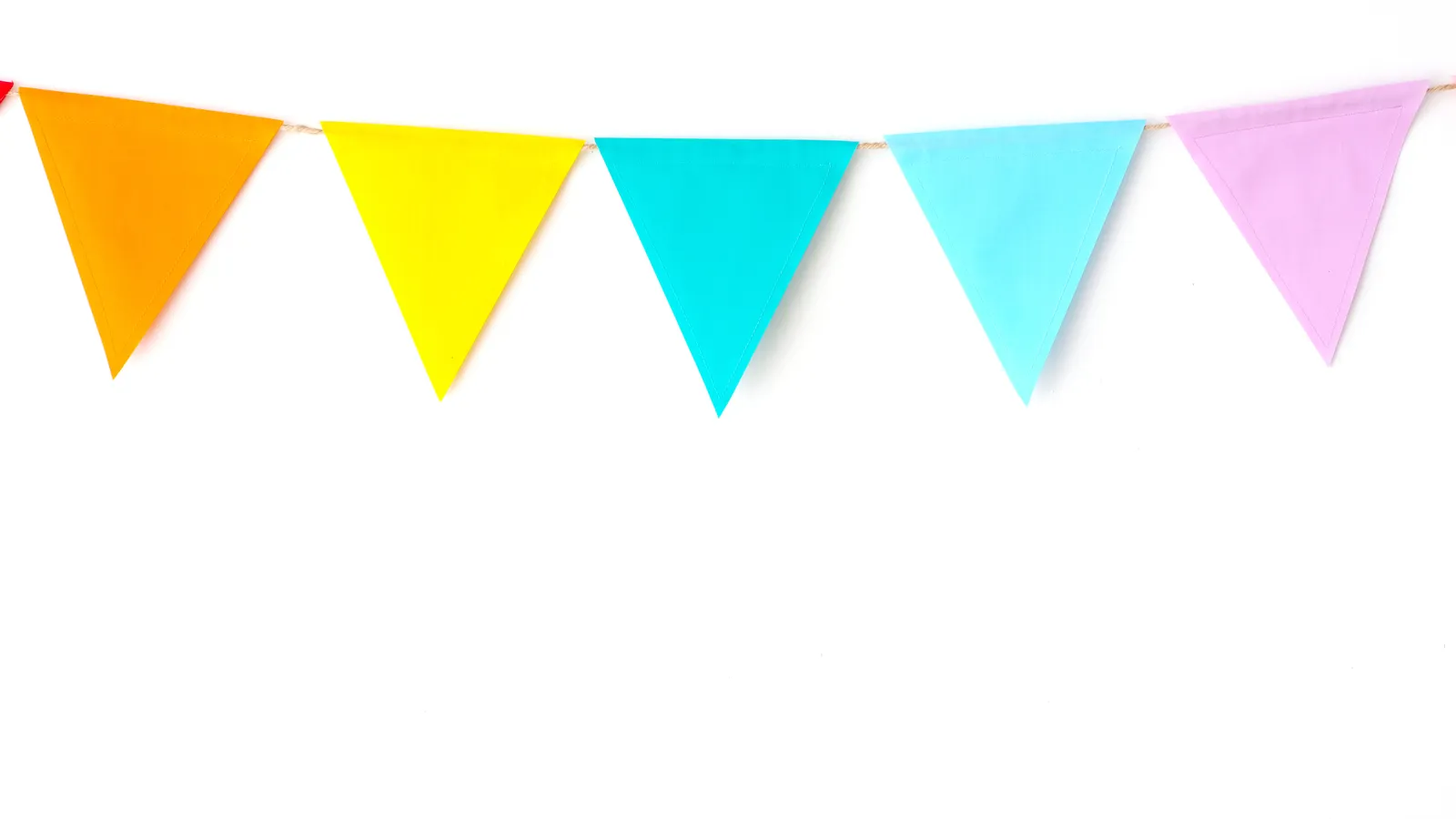 Colourful paper party bunting hanging against a white wall
