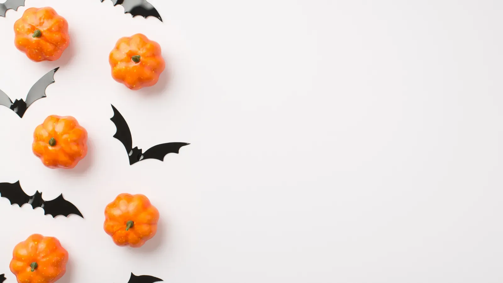 Small orange pumpkins arranged on a plain background for Halloween printables